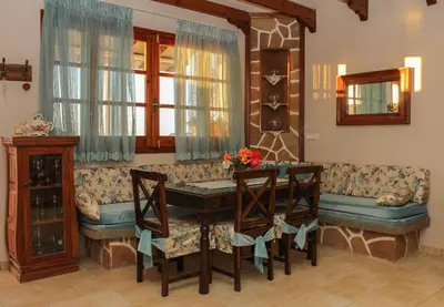 a living room with a couch and a table and chairs at Villa Limnioni in Archangelos