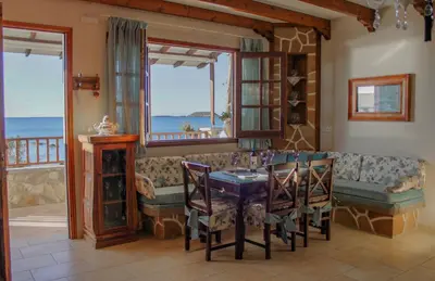 a dining room with a couch and a table with chairs at Villa Limnioni in Archangelos