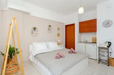 a bedroom with a bed with pink slippers on it at stegna on sea apt in Archangelos