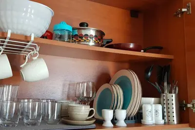 a kitchen shelf with plates and cups and dishes at stegna on sea apt in Archangelos