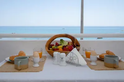 a breakfast table with a basket of fruit and eggs at stegna on sea apt in Archangelos
