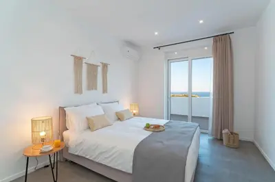 a bedroom with a large bed with a view of the ocean at Nora Villa in Afantou