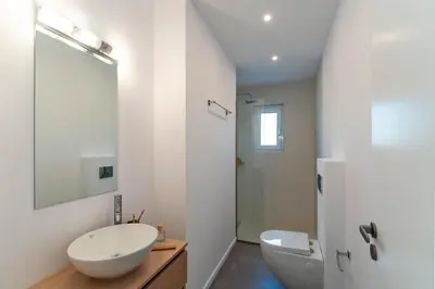 a white bathroom with a sink and a toilet at Nora Villa in Afantou