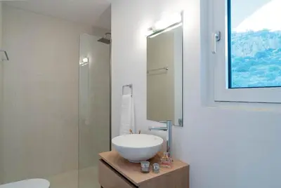 a bathroom with a sink and a glass shower at Nora Villa in Afantou