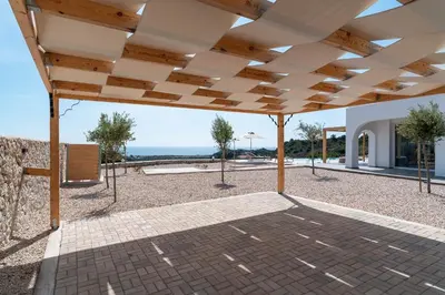 an open patio with a roof with a view of the ocean at Nora Villa in Afantou