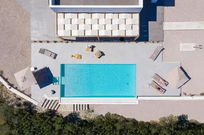 an overhead view of a swimming pool with chaise lounges at Nora Villa in Afantou