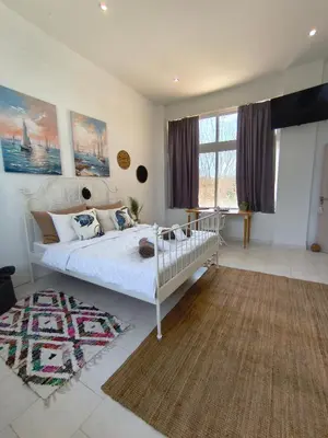 a bedroom with a white bed and a rug at Spacious Beach House Theologos in Theologos