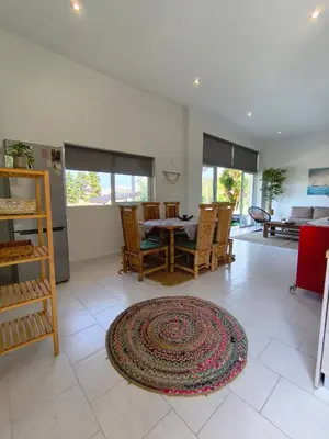 a living room with a table and chairs and a kitchen at Spacious Beach House Theologos in Theologos