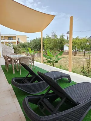 a patio with lawn chairs and a table with a tent at Spacious Beach House Theologos in Theologos