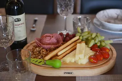 a plate of food on a table with a bottle of wine at Paraskevi Luxury Apartments in Kattavía
