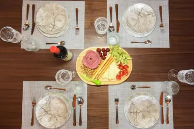 a table with plates of food and forks and glasses at Paraskevi Luxury Apartments in Kattavía