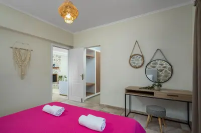 a bedroom with a pink bed and a desk and a mirror at Villa Palmeras in Soroni