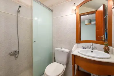 a bathroom with a toilet and a sink and a shower at Zenia Villa in Paradeísion