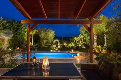 a backyard with a swimming pool and a pergola at Zenia Villa in Paradeísion