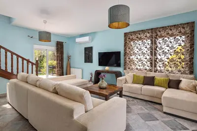 a living room with two couches and a table at Zenia Villa in Paradeísion