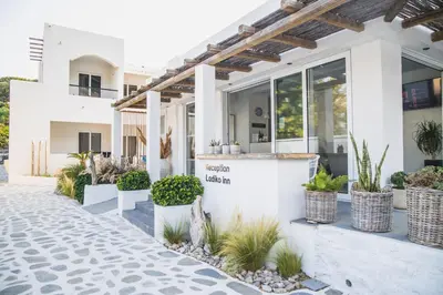 a white house with plants in front of it at Ladiko Inn Hotel Faliraki -Anthony Quinn Bay in Faliraki