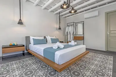 a bedroom with a large bed with blue pillows at Amarada City Suites in Rhodes Town