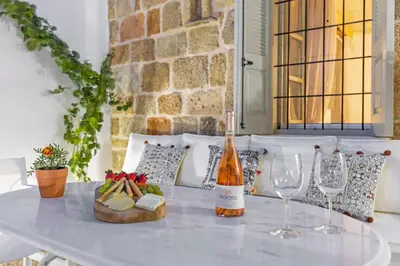 a table with a bottle of wine and wine glasses at Amarada City Suites in Rhodes Town