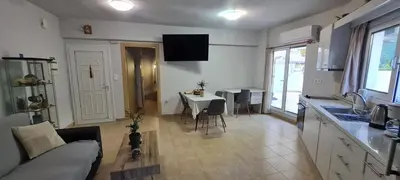 a kitchen and a living room with a table and a couch at Annie's Apartment in Ialyssos