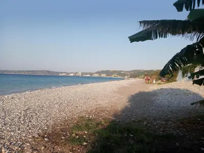 a beach with a rocky shore and the ocean at Annie's Apartment in Ialyssos
