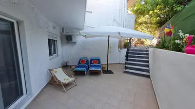 two chairs and an umbrella on a patio at Annie's Apartment in Ialyssos