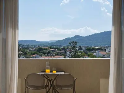a table and two chairs on a balcony with a view at Atlantica Princess Hotel in Ixia