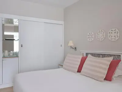 a white bedroom with a white bed with red and white pillows at Atlantica Princess Hotel in Ixia