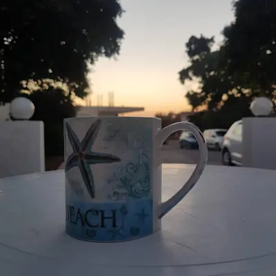a coffee cup with a star on it sitting on a table at Lilly Rooms in Faliraki