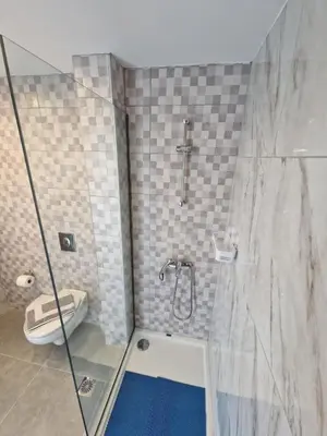 a bathroom with a shower and a toilet at Lilly Rooms in Faliraki