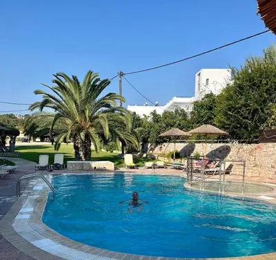 a man in a swimming pool in a resort at Lilly Rooms in Faliraki