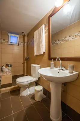 a bathroom with a sink and a toilet and a mirror at Margarita luxury apartment 2 in Faliraki
