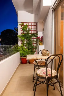 a balcony with two chairs and a table and a window at Margarita luxury apartment 2 in Faliraki