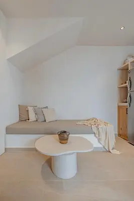 a living room with a couch and a table at Noema Lindos - Agapitos Apartment in Líndos