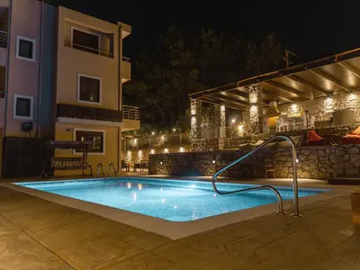 a swimming pool in a resort at night at Adonis Villa in nature in Ixia