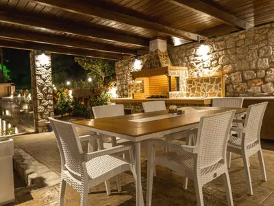 an outdoor kitchen with a wooden table and chairs at Adonis Villa in nature in Ixia