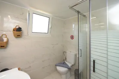 a bathroom with a toilet and a glass shower at Alion House in Rhodes Town