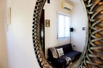 a mirror reflection of a couch in a living room at Alion House in Rhodes Town