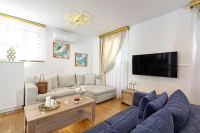 a living room with a couch and a tv at Villa Dafni - Lindos in Líndos