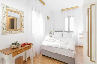 a bedroom with a bed with a mirror and a table at Villa Dafni - Lindos in Líndos