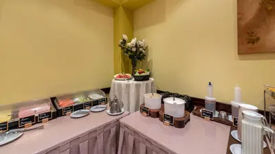 a room with a table with plates and a vase of flowers at Marine Congo Hotel in Rhodes Town