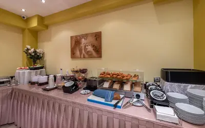 a table with plates and food on top of it at Marine Congo Hotel in Rhodes Town