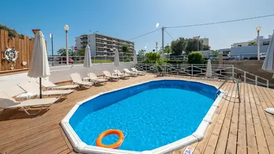 a swimming pool on a deck with chairs and umbrellas at Marine Congo Hotel in Rhodes Town