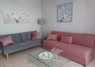 a living room with a purple couch and pink pillows at Melenia Suites in Rhodes Town