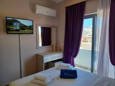 a bedroom with a bed with a tv and a window at Melenia Suites in Rhodes Town