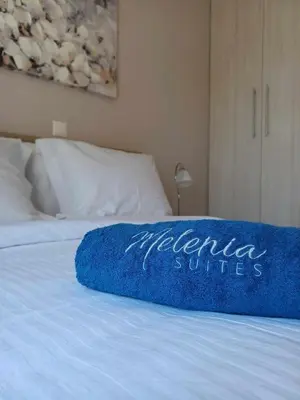 a blue blanket on top of a bed at Melenia Suites in Rhodes Town