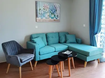 a living room with a blue couch and a chair at Melenia Suites in Rhodes Town