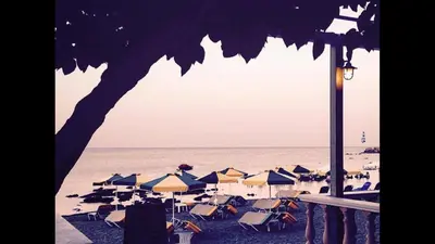 a group of beach chairs and umbrellas on a beach at Paradise Studios in Faliraki