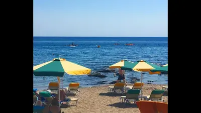 a group of chairs and umbrellas on a beach at Paradise Studios in Faliraki