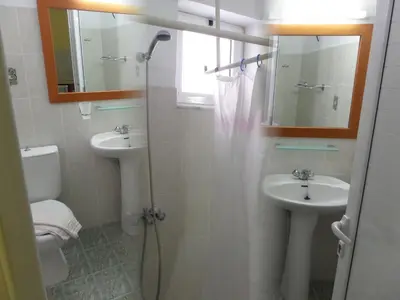 a bathroom with two sinks and a shower and a toilet at Paradise Studios in Faliraki