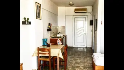a kitchen with a table and chairs and a door at Paradise Studios in Faliraki